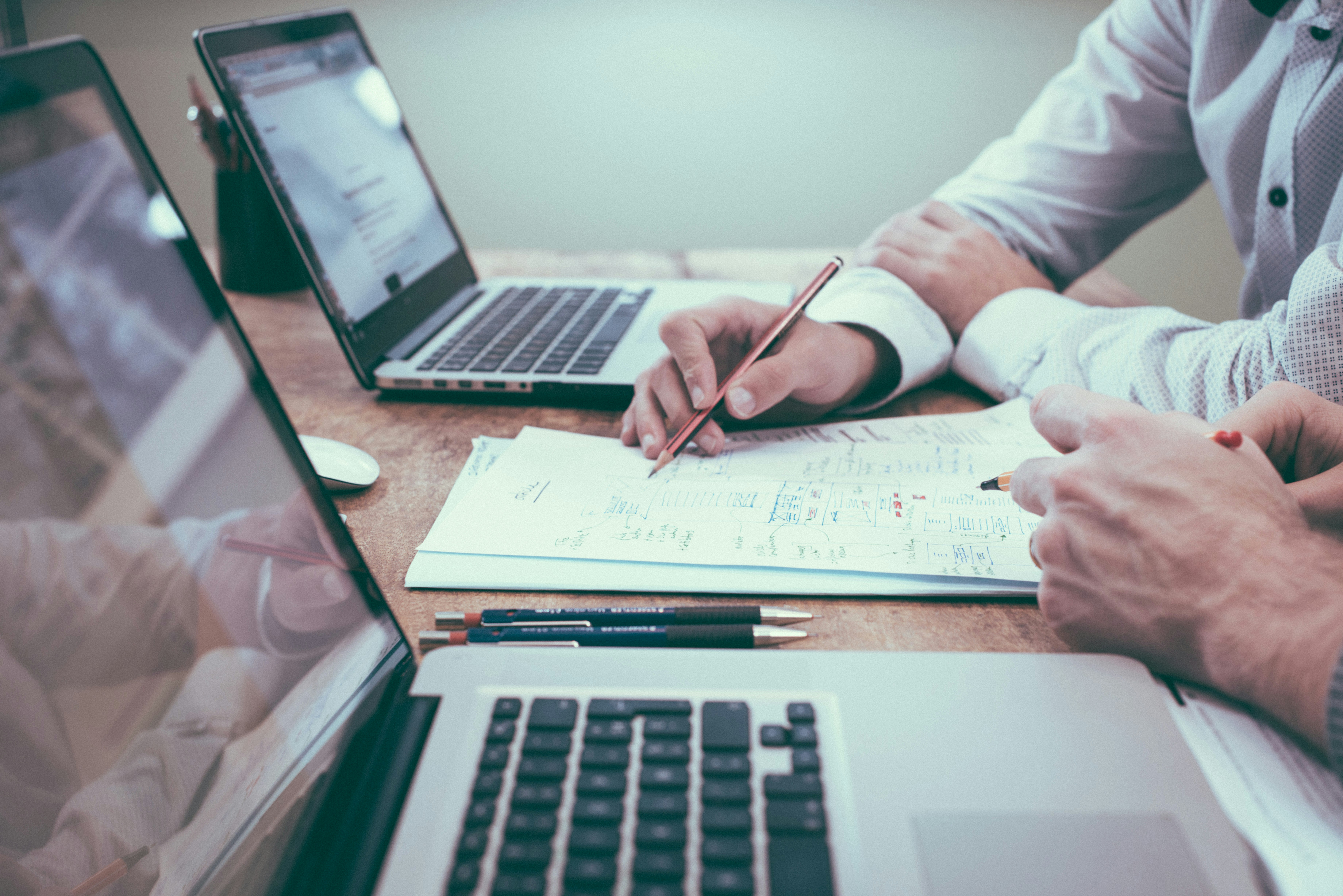Equipe em reunião de consultoria estratégica, analisando gráficos e processos.